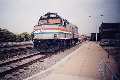 Lonely Cab-baggage unit sits next to closed station in Pontiac; CN freight about to pass by on the main